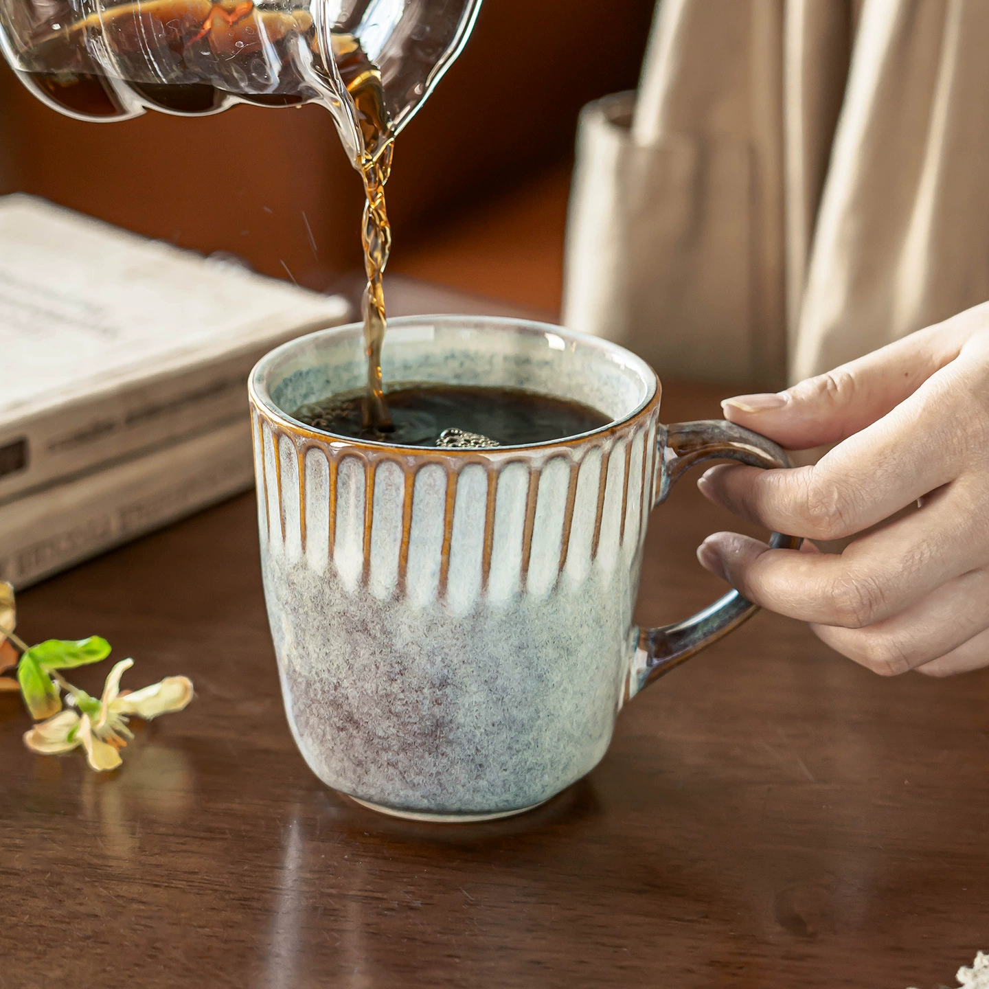 Pouring coffee into a reactive glaze ceramic mug