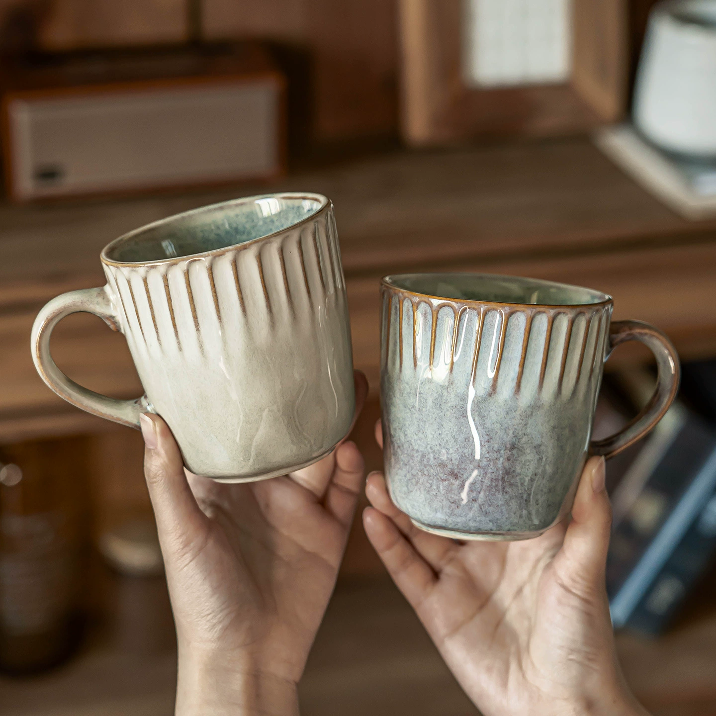 Two reactive glaze ceramic mugs in beige and blue grey finishes