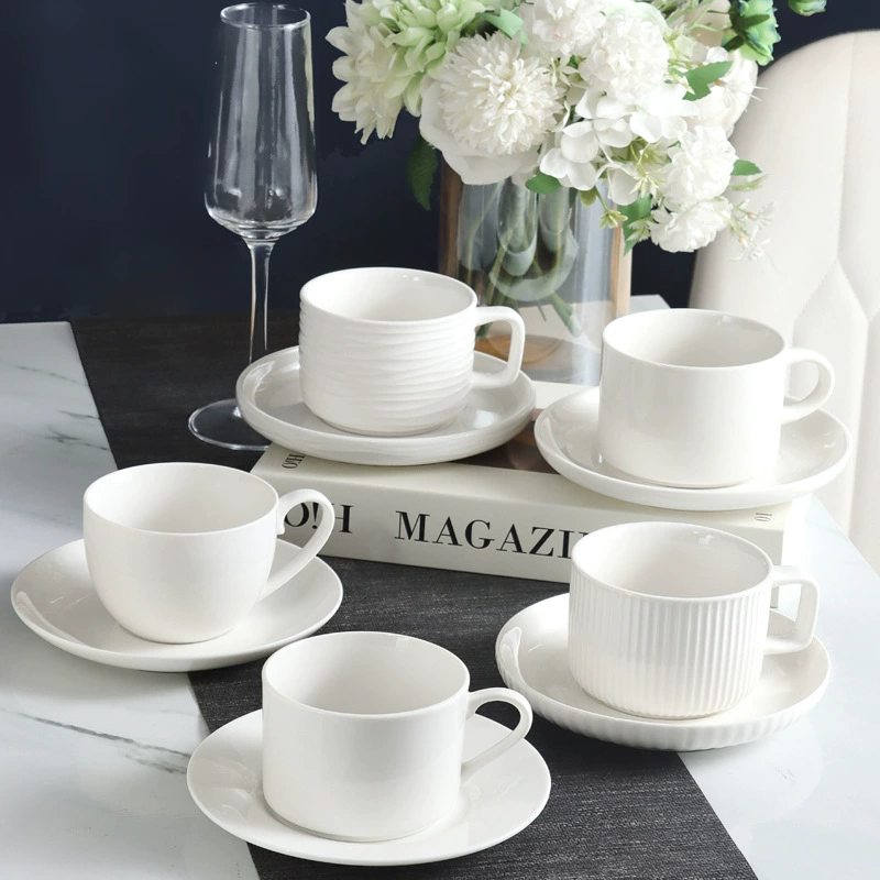 Multiple white ceramic cups and saucers in different shapes