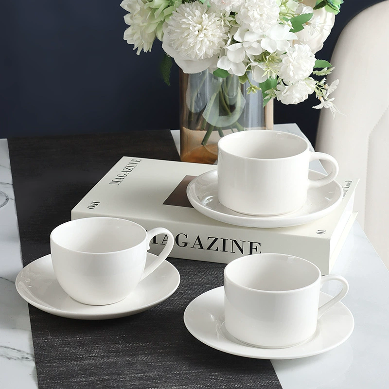 Three smooth white ceramic coffee cups with saucers
